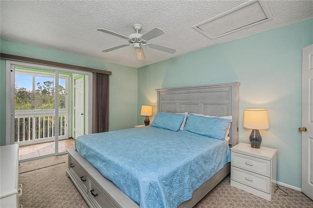 22375 Edgewater Drive, Unit 238 Punta Gorda, FL 33980 - Photo 21 of 57 a bedroom with a large bed and a chandelier