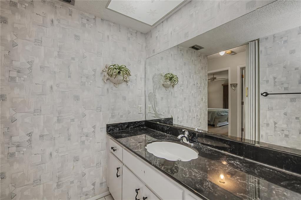 22375 Edgewater Drive, Unit 238 Punta Gorda, FL 33980 - Photo 32 of 57 a bathroom with a granite countertop sink and a mirror