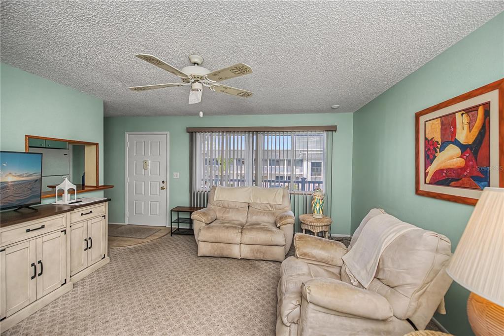 22375 Edgewater Drive, Unit 238 Punta Gorda, FL 33980 - Photo 9 of 57 a living room with furniture a ceiling fan and a rug