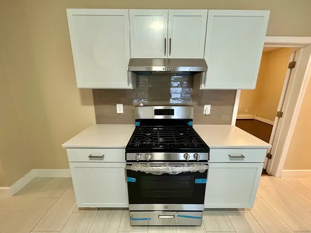 a stove top oven sitting inside of a kitchen