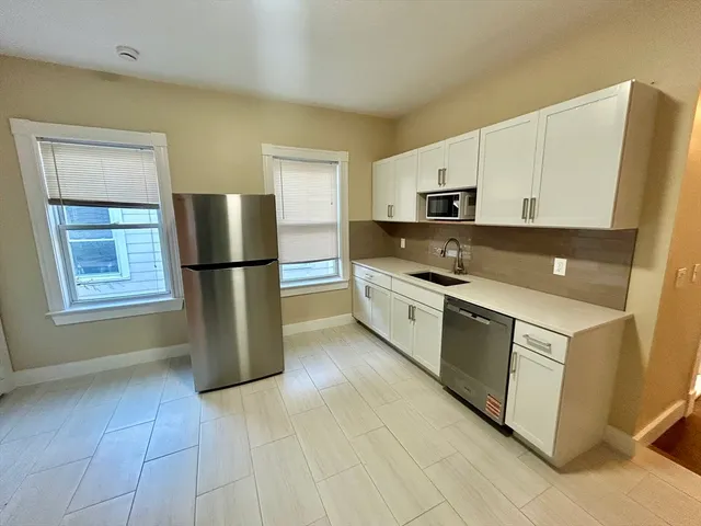 a kitchen with a refrigerator sink and cabinets