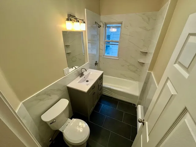 a bathroom with a toilet sink and mirror