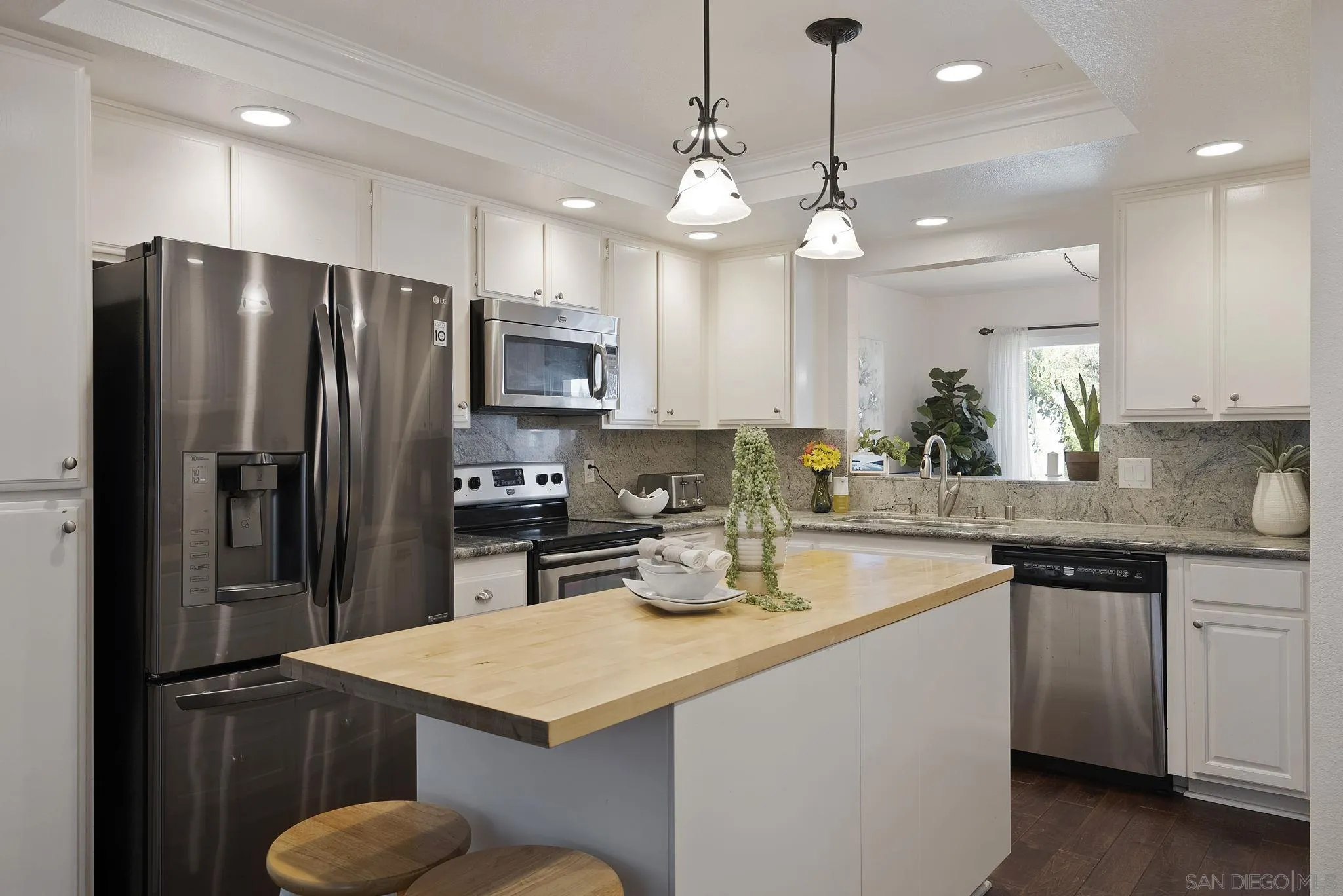 6561 Corte Cisco Carlsbad, CA 92009 - Photo 13 of 36 a kitchen with kitchen island a sink stainless steel appliances and cabinets