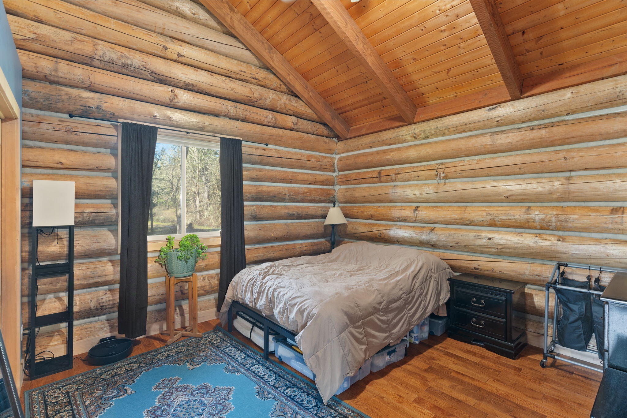 5737 Rockydale Road Cave Junction, OR 97523 - Photo 9 of 39 a bedroom with a bed and a dresser next to a window