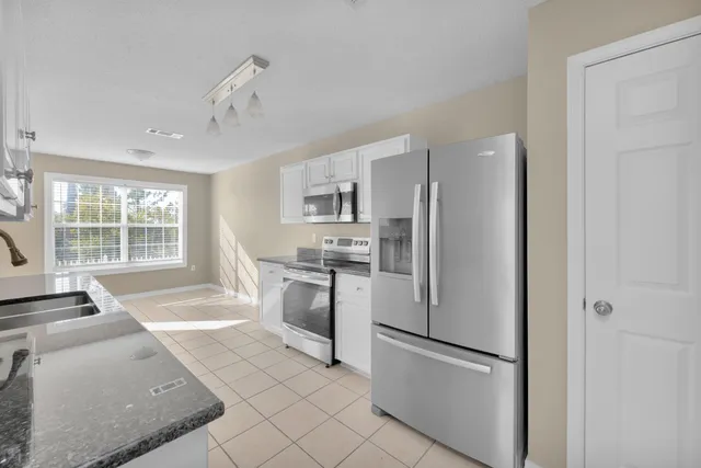 a kitchen with stainless steel appliances granite countertop a sink stove and cabinets