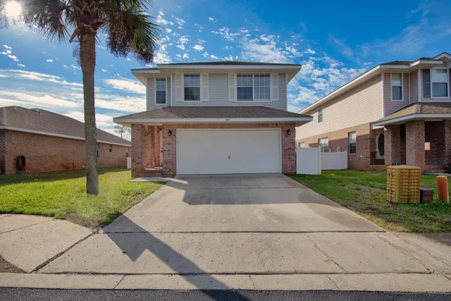 a front view of a house with a yard and a garage