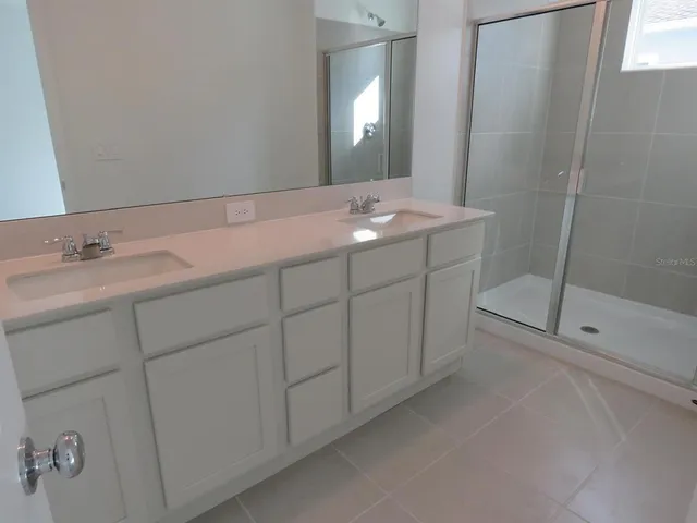 a bathroom with a double vanity sink and mirror