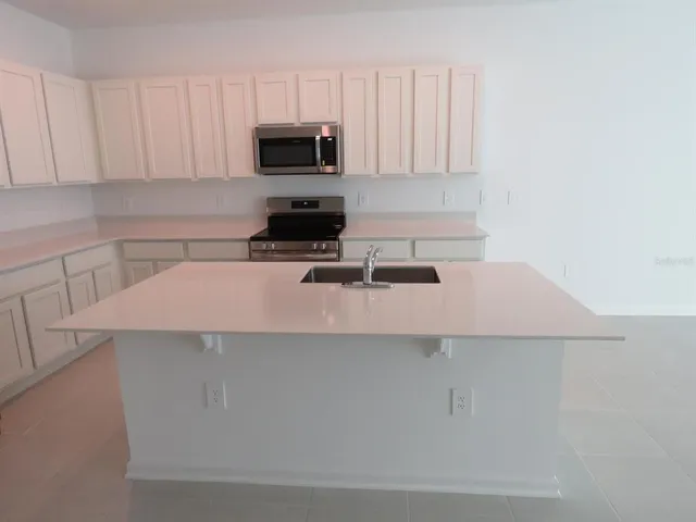a kitchen with a sink a microwave and cabinets