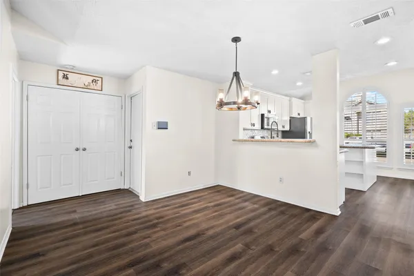 a view of a kitchen with wooden floor and window