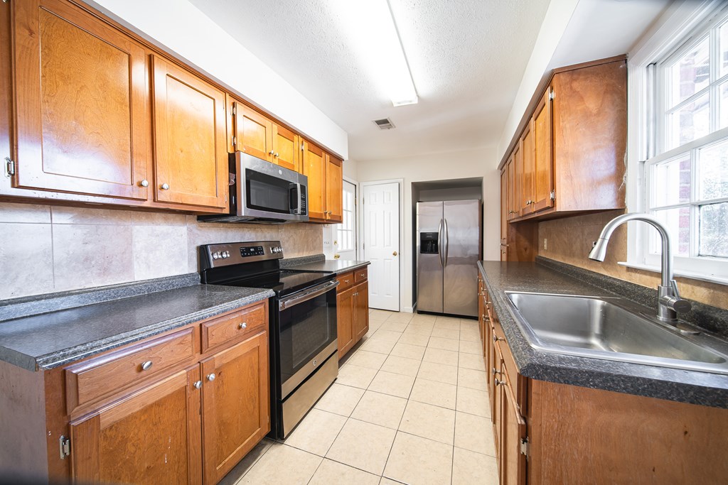 1829 Celeste Drive Columbus, GA 31907 - Photo 6 of 33 a kitchen with granite countertop a sink a counter top space appliances and cabinets