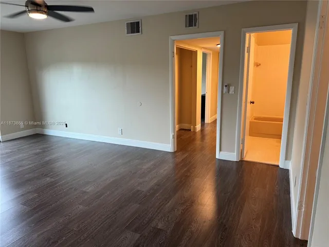 an empty room with wooden floor and door