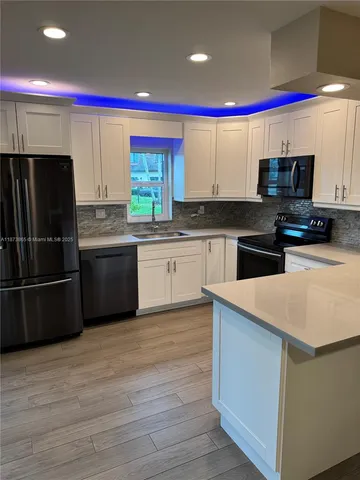a kitchen with stainless steel appliances a stove a sink and a refrigerator
