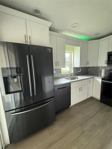 a kitchen with a refrigerator sink and cabinets