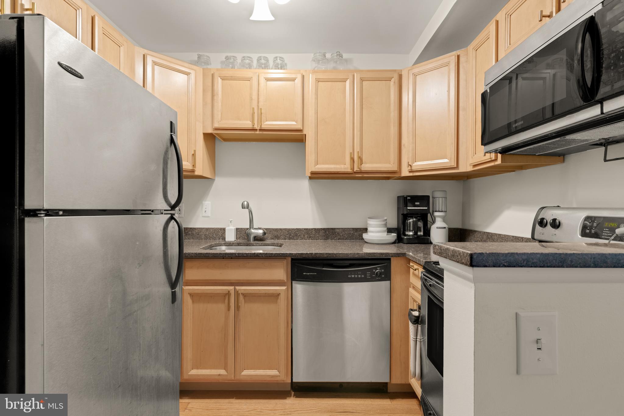 512 Cathedral Street, Unit 3 Baltimore, MD 21201 - Photo 14 of 38 a kitchen with stainless steel appliances granite countertop a refrigerator sink and cabinets