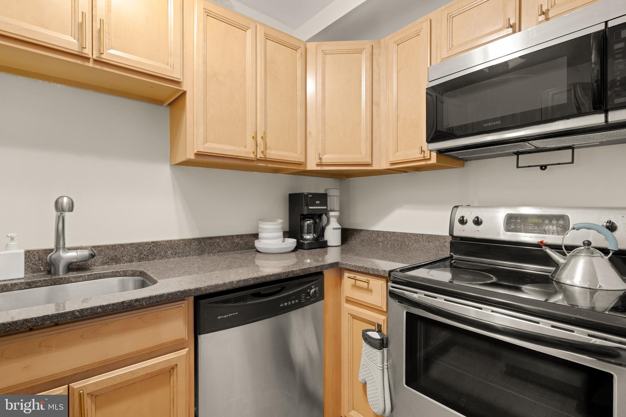 512 Cathedral Street, Unit 3 Baltimore, MD 21201 - Photo 15 of 38 a kitchen with stainless steel appliances granite countertop a sink stove and microwave