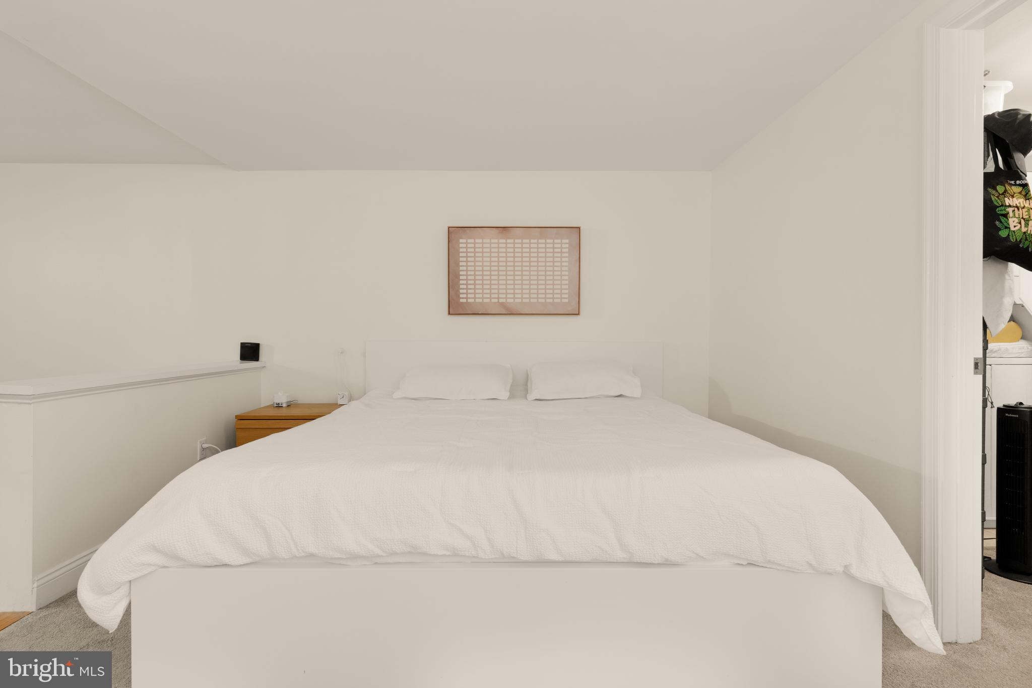 512 Cathedral Street, Unit 3 Baltimore, MD 21201 - Photo 22 of 38 a bedroom with a bed and a wall painting