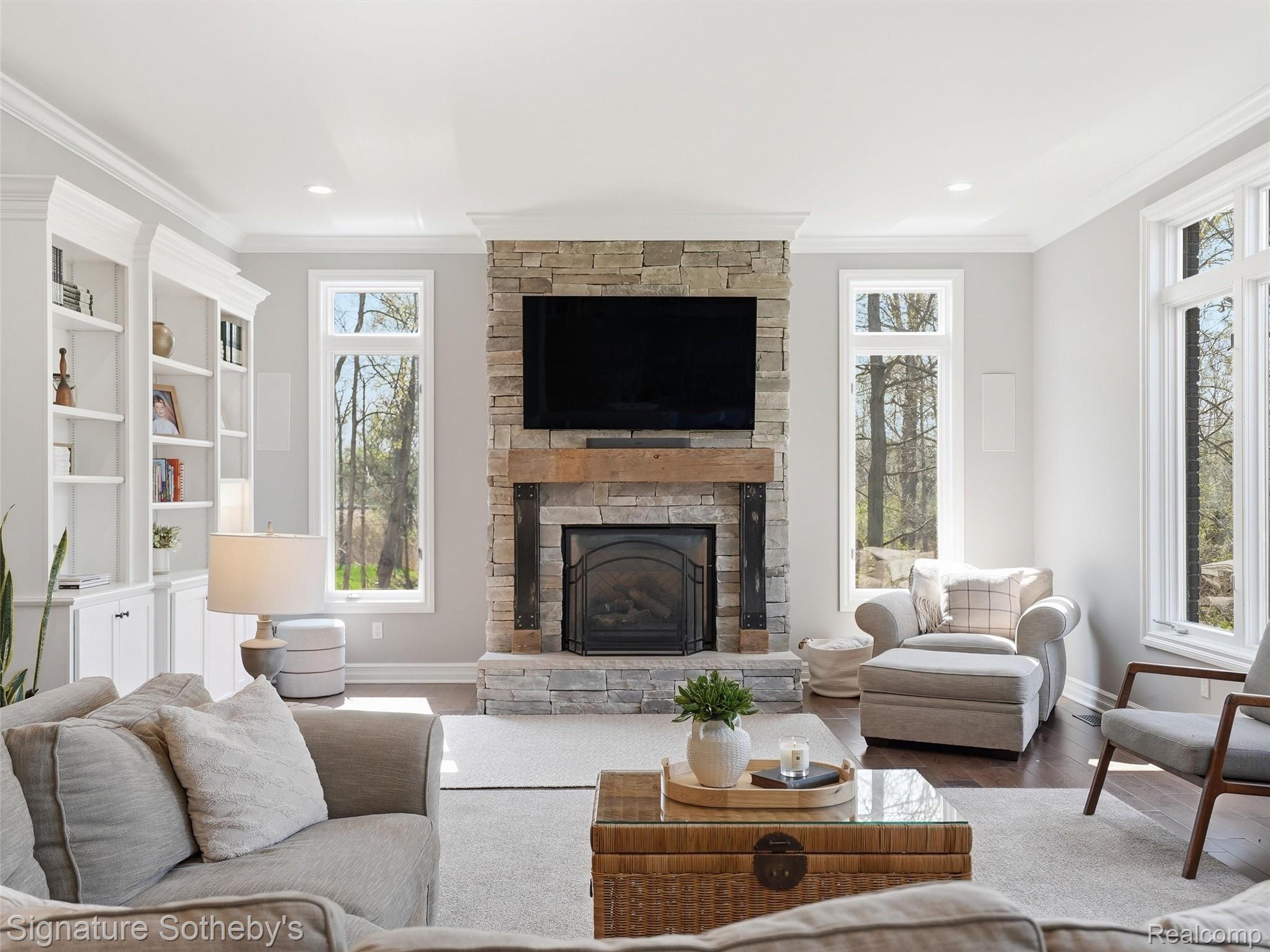 1595 Carriage Way Rochester, MI 48307 - Photo 23 of 78 Living room with crown molding, wood finished floors, and a stone fireplace