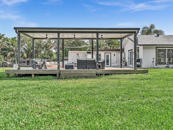 a living room with stainless steel appliances furniture and a kitchen view