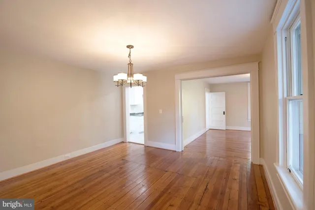 a view of a room with wooden floor staircase and a kitchen