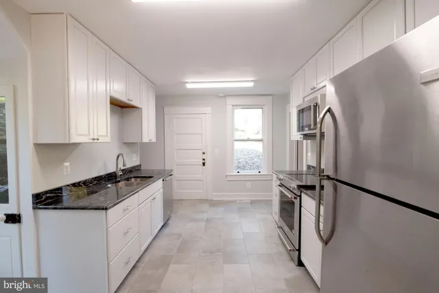 a kitchen with a refrigerator a stove and cabinets