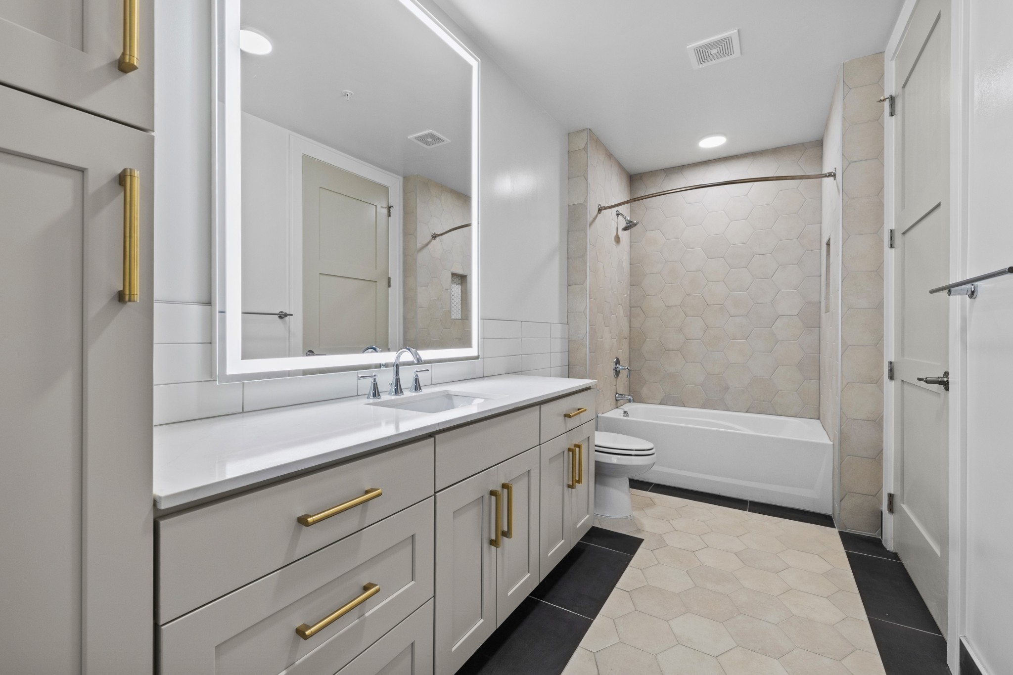 930 Commerce Street, Unit 508 Nashville, TN 37203 - Photo 21 of 65 a bathroom with a double vanity sink toilet mirror and bathtub