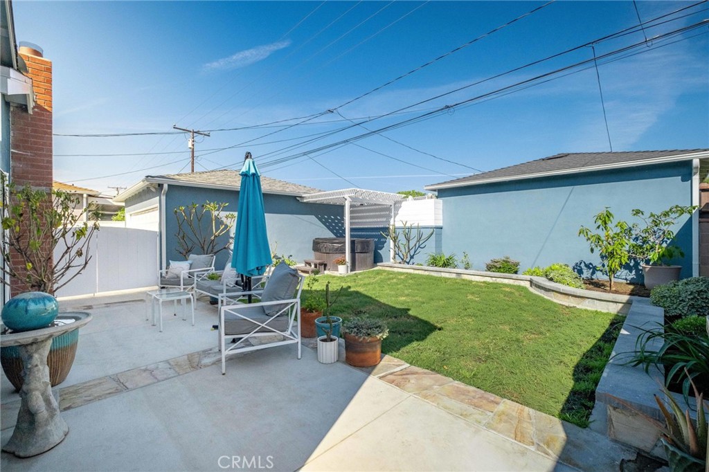 3638 North Studebaker Road Long Beach, CA 90808 - Photo 38 of 55 a view of a patio with table and chairs potted plants and wooden fence
