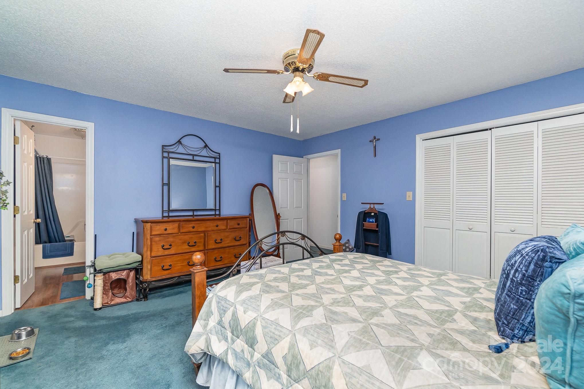 21014 Pine Ridge Drive Cornelius, NC 28031 - Photo 14 of 33 a bed room with a bed and a chandelier