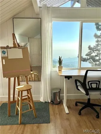 a view of a workspace with furniture and a window
