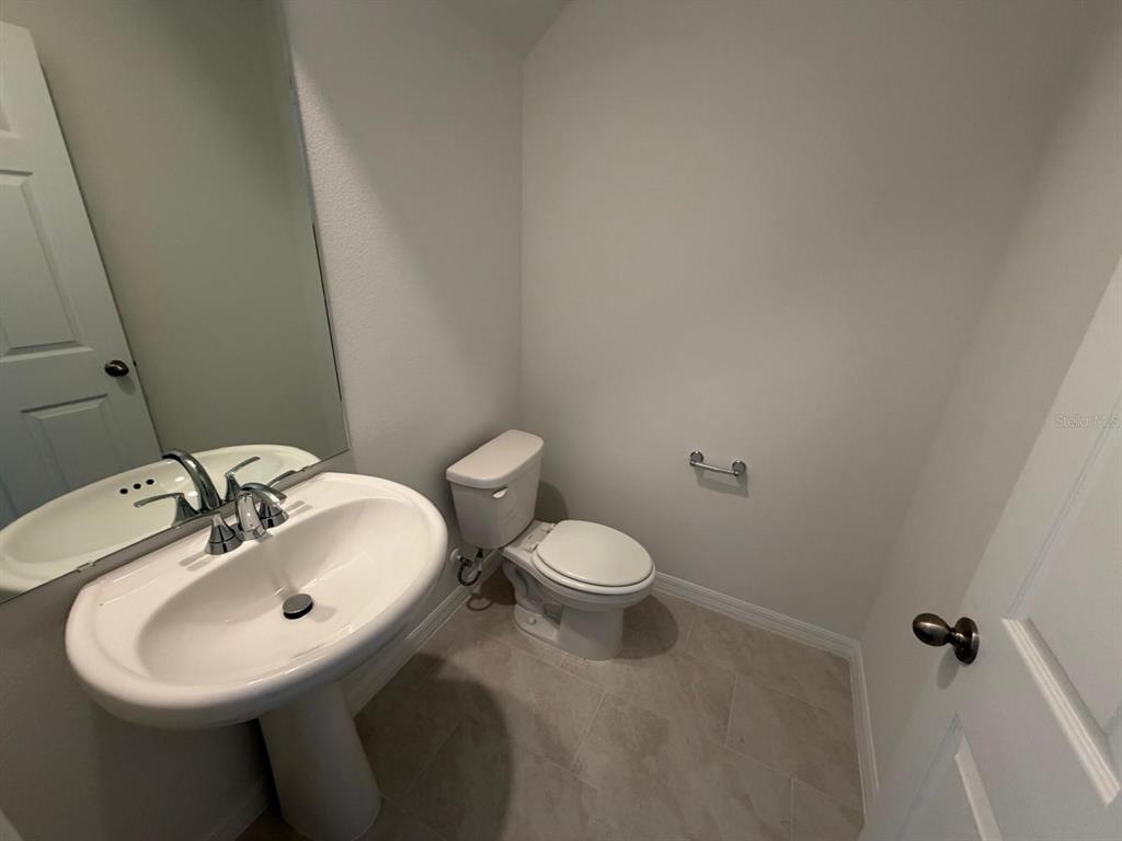 4244 Ranch House Road St. Cloud, FL 34772 - Photo 22 of 34 a bathroom with a sink a toilet and mirror