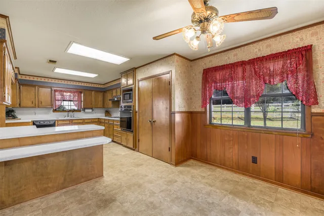 a large kitchen with stainless steel appliances granite countertop a refrigerator and a sink