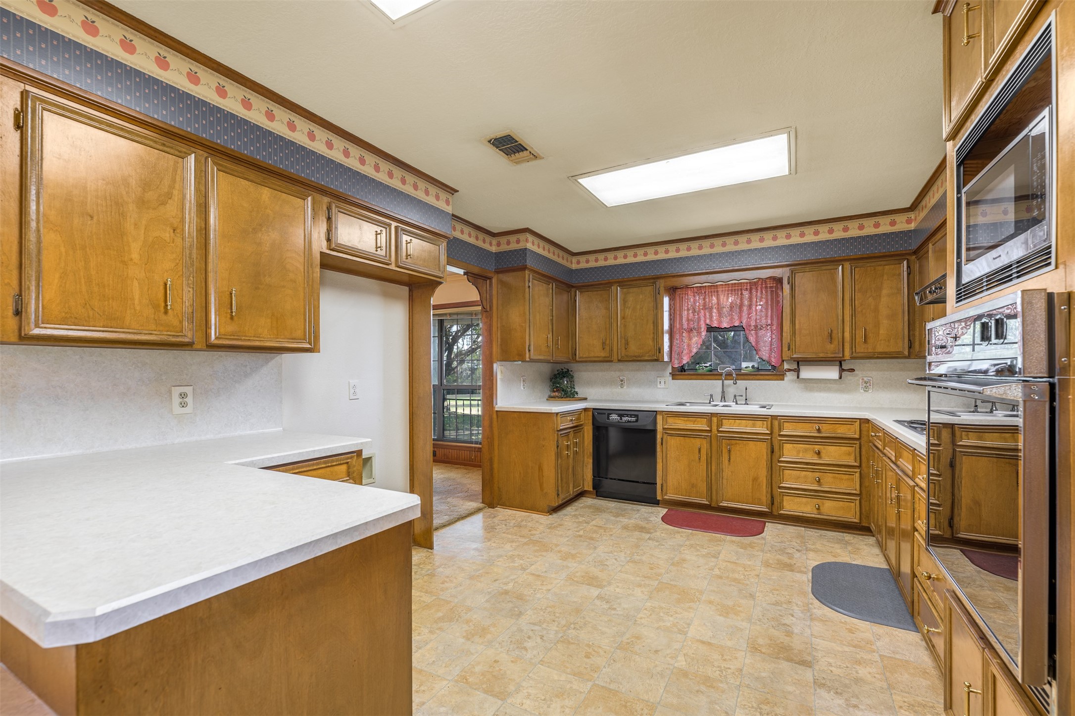 6700 FM 332 Road Brenham, TX 77833 - Photo 16 of 36 a kitchen with a refrigerator a stove top oven a sink a dining table and chairs