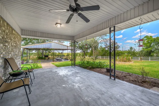 a view of a patio with a table chairs and a backyard
