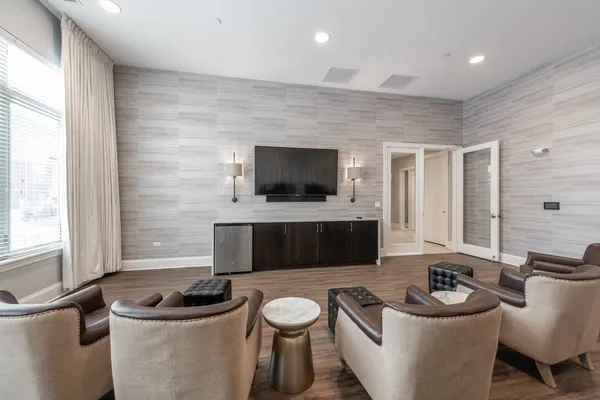 a living room with furniture a flat screen tv and a window