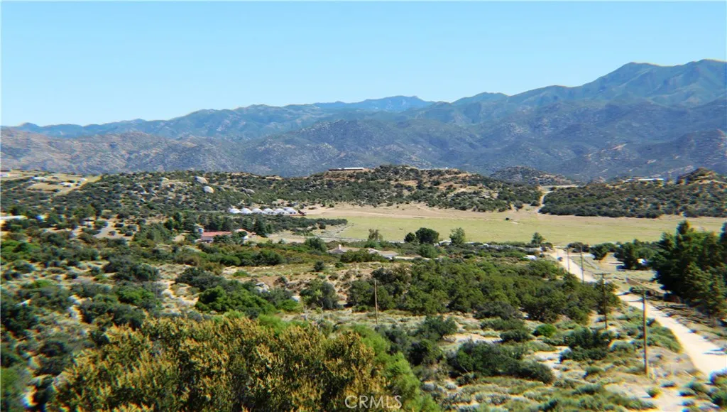 an aerial view of mountain with residential house and green space