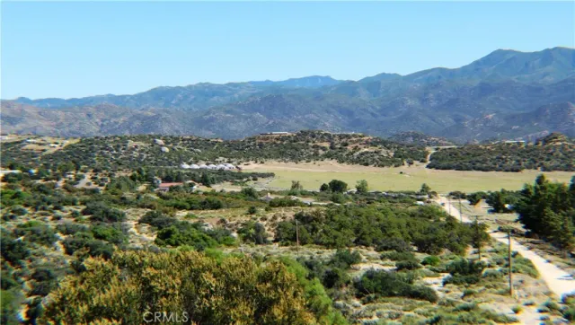 an aerial view of mountain with residential house and green space