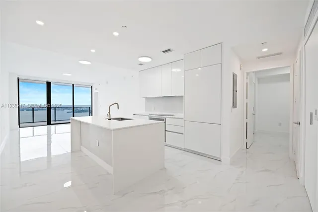 a view of a kitchen with a sink and dishwasher with white walls