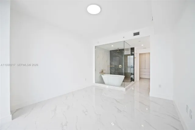 an empty room with kitchen view