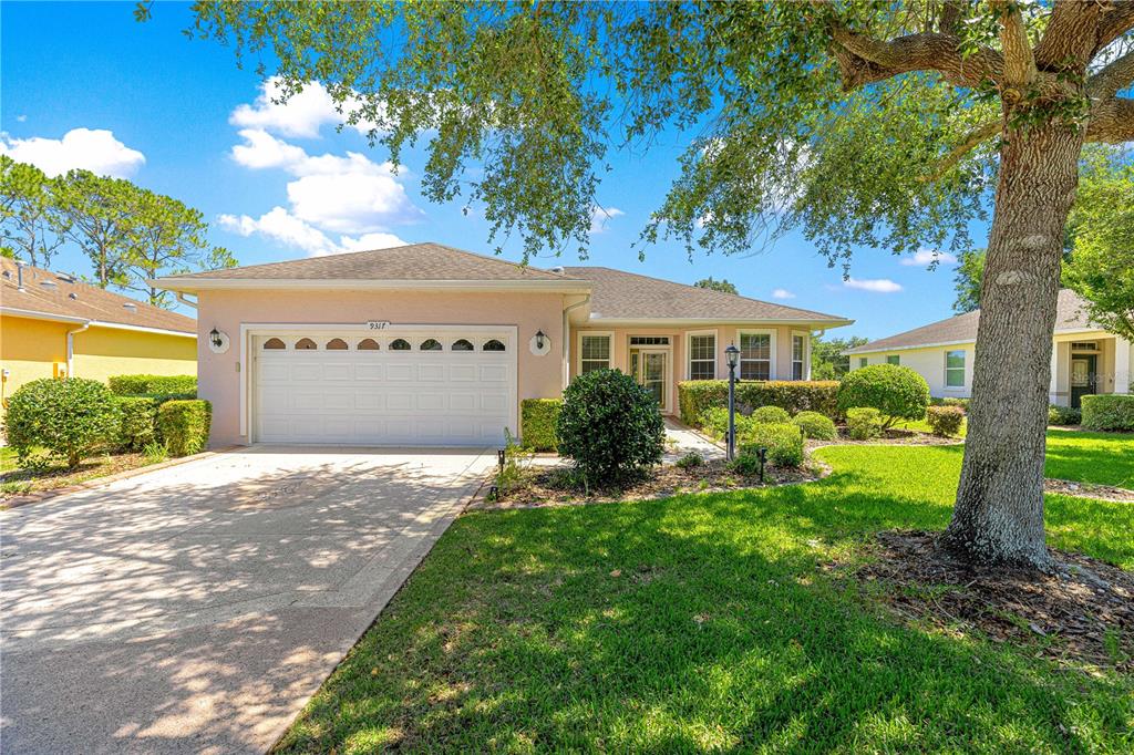 9317 Southwest 94th Loop Ocala, FL 34481 - Photo 1 of 40 a front view of a house with a yard and garage