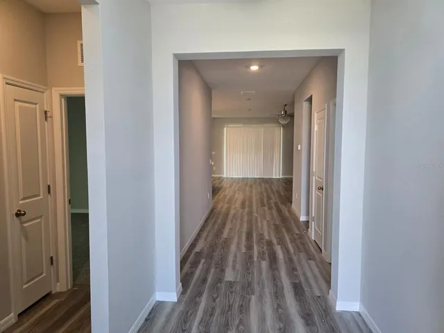 a view of a hallway with wooden floor