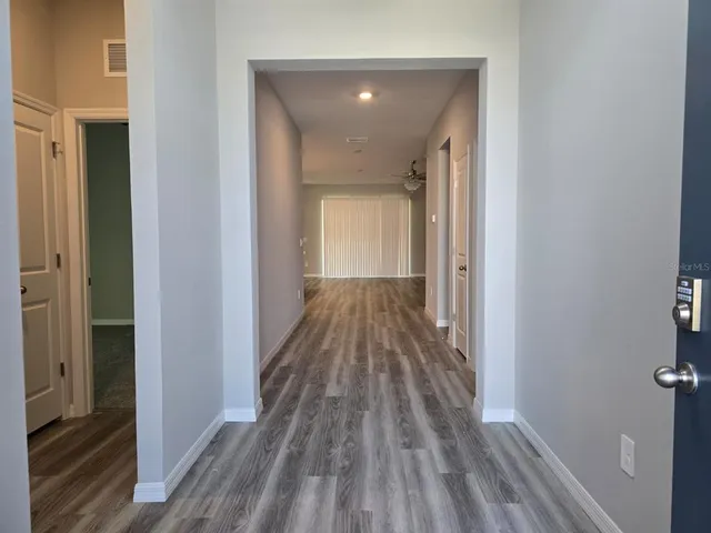 a view of a hallway with wooden floor