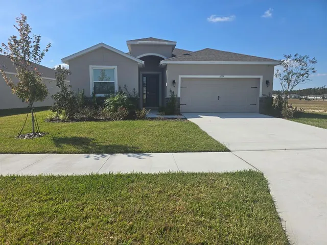 a front view of a house with a yard and garage