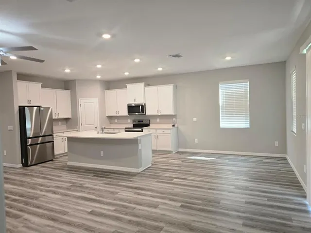 a large kitchen with kitchen island a sink stainless steel appliances and cabinets