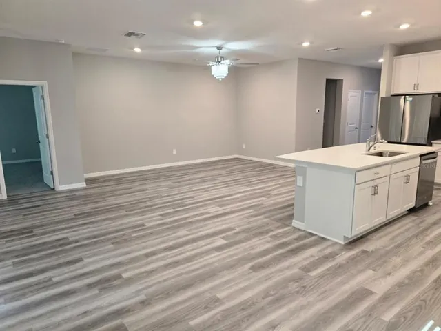 a view of kitchen with cabinets stainless steel appliances with wooden floor