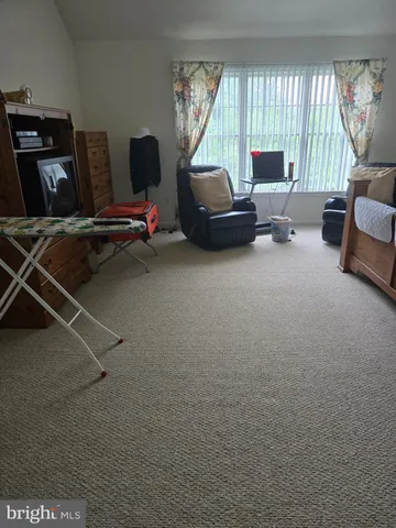 a living room with furniture a window and a flat screen tv