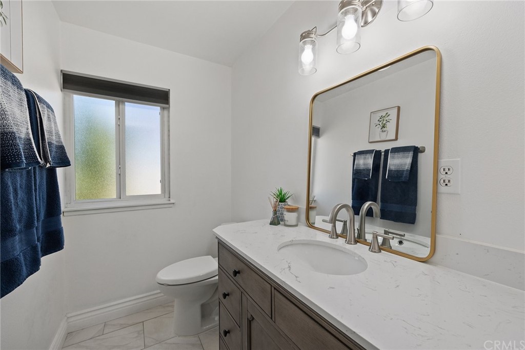 10221 Beaver Circle Cypress, CA 90630 - Photo 11 of 26 a bathroom with a toilet sink and mirror