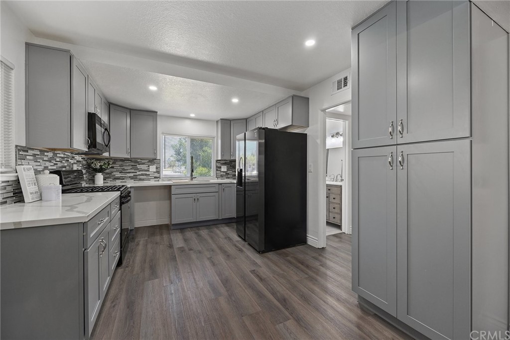 10221 Beaver Circle Cypress, CA 90630 - Photo 4 of 26 a kitchen with a refrigerator a sink and cabinets