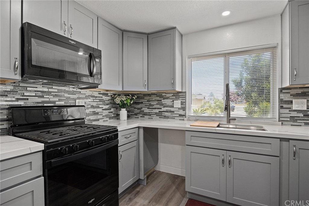 10221 Beaver Circle Cypress, CA 90630 - Photo 6 of 26 a kitchen with stainless steel appliances a sink stove and microwave