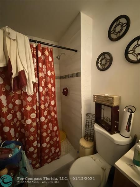 a bathroom with a toilet and a shower curtain