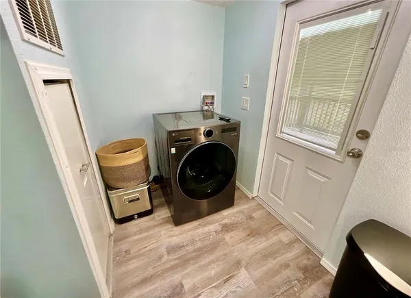 a living room with stainless steel appliances furniture and a flat screen tv