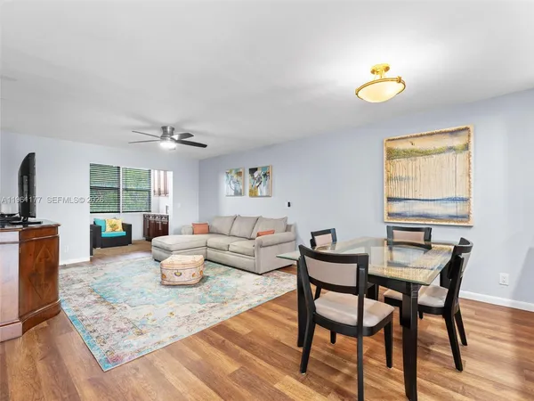 a living room with dining room and wooden floor